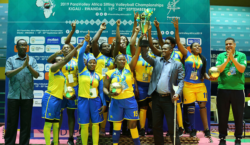 Senate President Bernard Makuza (extreme left), MP Eugu00e8ne Mussolini and coach Mosaad Rashad Elaiuty (extreme right) join Rwandau2019s female Sitting Volleyball team in celebrations after coming from a set down to win 3-1 against Egypt at Amahoro Indoor Stadium in Kigali yesterday to become African champions, and effectively earn the sole African ticket to 2020 Paralympic Games in Tokyo, Japan. Photo/Sam Ngendahimana.