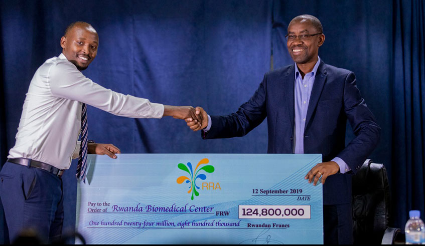 RBC director-general Dr Sabin Nsanzimana (left) receives the dummy cheque from Rwanda Revenue Authority boss Pascal Bizimana Ruganintwari. Courtesy.