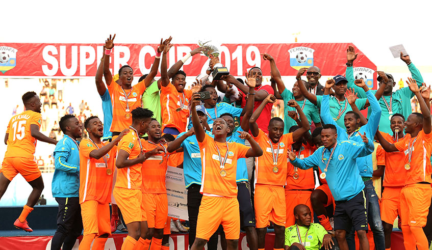 AS Kigali players and technical staff (top-right) celebrate with their medals, trophy and Rwf5million dummy cheque after ousting Rayon Sports to win the 2019 Super Cup title at Amahoro Stadium yesterday. Sam Ngendahimana.