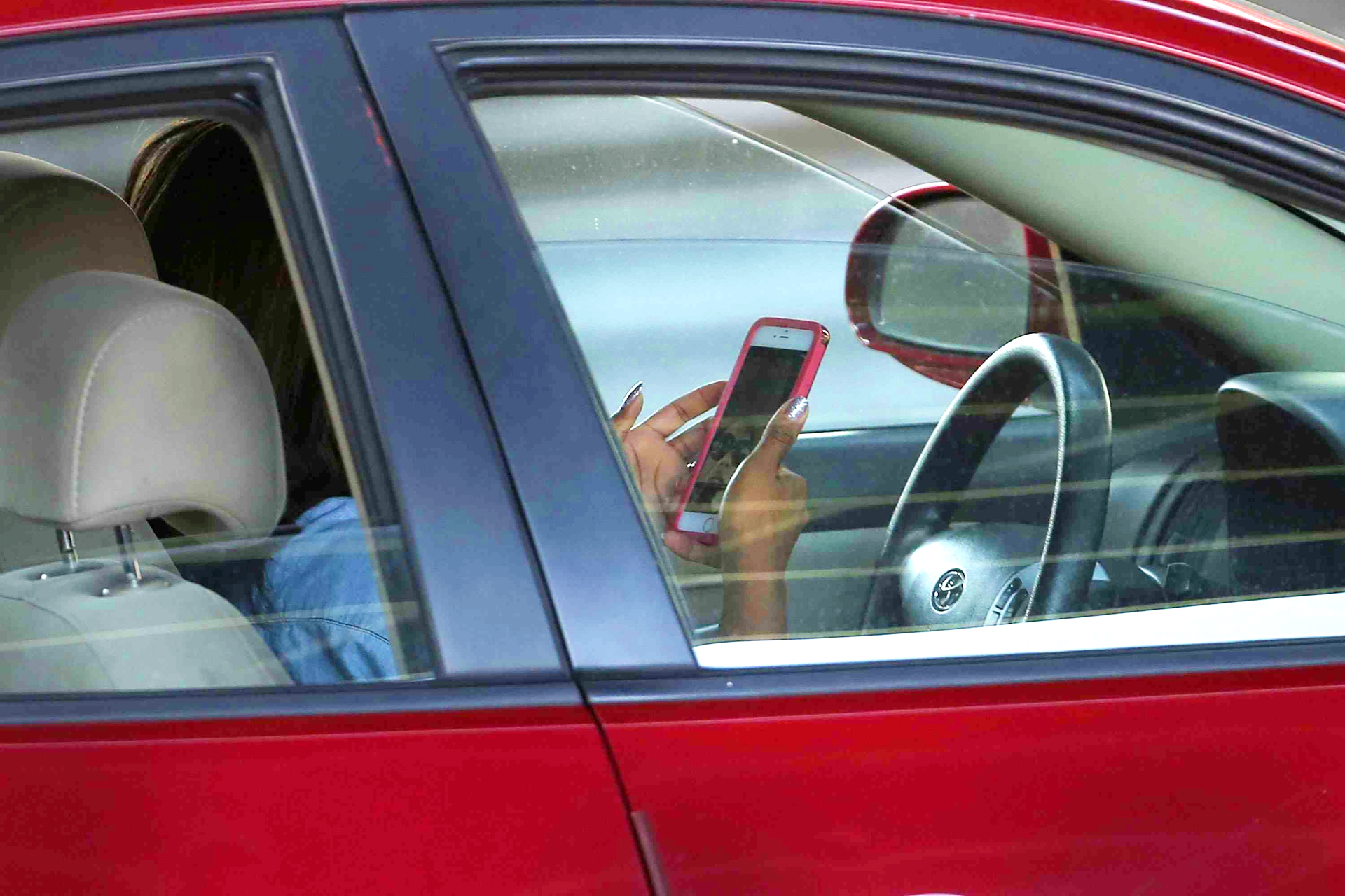 A driver using a smartphone which might lead to an accident among other risks/ Net photo
