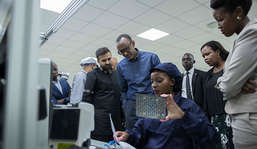 President Kagame together with other officials (L-R); Ashish Thakkar, the CEO of the Mara Group, Clare Akamanzi, the chief executive of Rwanda Development Board and the Minister for ICT and Innovation Paula Ingabire inspect one of the production units of Mara Phones. The plant, once at full capacity, will be able to manufacture up to one million phones a year. The firm targets regional and the continental market for their smartphones.  Photo/Village Urugwiro.