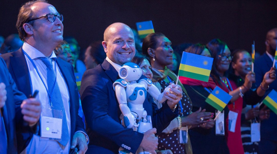 Fabrice Goffin (2nd left) waves a Rwandan flag as he holds one of the robots produced by his company, ZoraBots, during Rwanda Day in Bonn, Germany over the weekend. / Courtesy