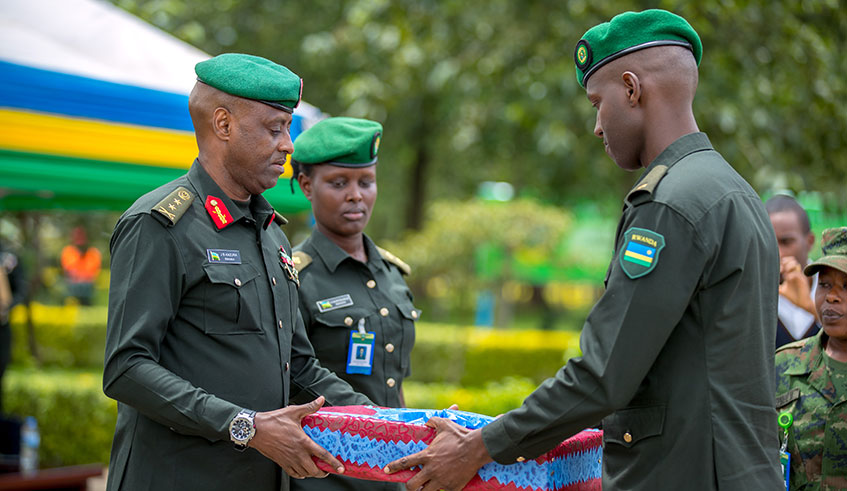 Maj Gen Kazura, the RDF Command and Staff College Commandant, awards Maj Ru00e9gis Rwagasana Sankara, who emerged the best student. Courtesy.