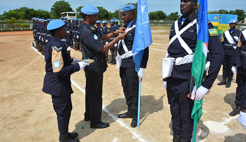 UNPOL Chief of Staff, ACP Barthelemy Rugwizangonga decorates one of the Police officers