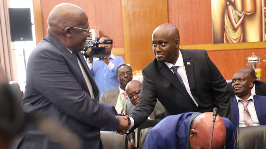 Amb. Olivier Nduhungirehe, Rwanda's Minister of State in charge of the East African Community (right), shakes hands with Ugandan Foreign Affairs minister Sam Kuteesa during the first meeting of the ad hoc commission on the implementation of the Luanda MoU between Rwanda and Uganda in Kigali last month.