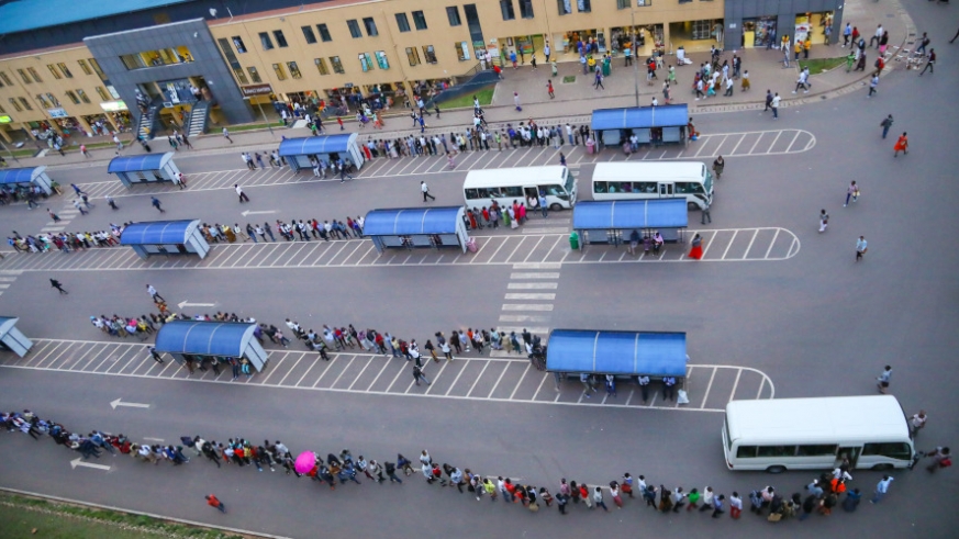 Passengers queue as they wait for buses at the taxi park in downtown Kigali in June. File