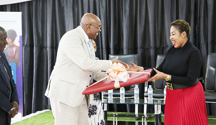 The chairman and founder Prof. Simon Gicharu hands over the gift to Rita Okuthe  during the meeting of Innovation for women at mount kenya university, Craish Bahizi 