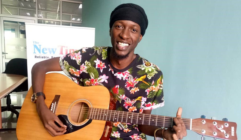Joel Ruti plays a guitar after an interview at The New Times offices on October 13.  Faustin Niyigena.