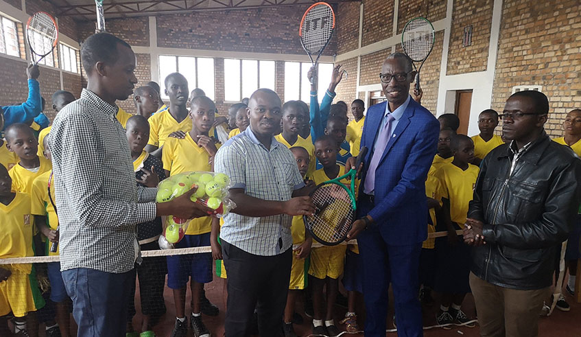 FRT Secretary general, Valens Habimana hands over tennis equipment to John Bosco Ntamagiro, the Director of the Deaf School. Jejje Muhinde.