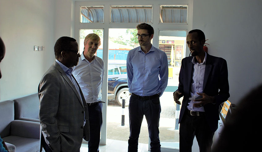 BBOXX Rwanda's MD, Justus Mucyo (R) welcomes Minister Vincent Biruta (L)to the BBOXX Cook Shop. Looking on is Group Director of Commercial and Innovation Ulrich Reinecker and Paul Buttner, Product Manager , BBOXX Cook. (Courtesy)
