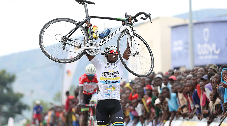 Renus Byiza Uhiriwe, 19, lifts his bicycle to celebrate his solo victory after crossing the finish-line in Muhanga on Saturday. / Sam Ngendahimana