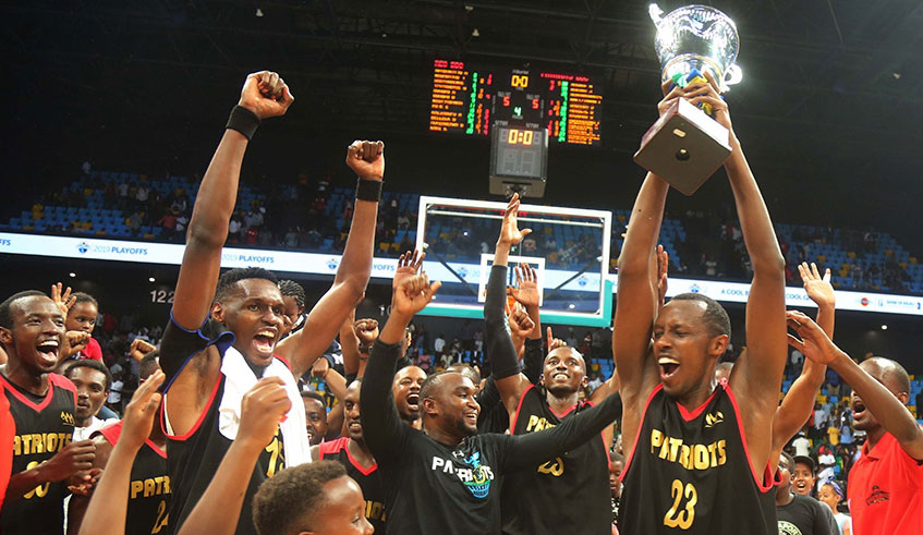 Steven Hagumintwari, who scored 8 points in Game 7, lifts the trophy aloft after Patriots edged REG 65-59 to retain the Bank of Kigali Basketball National League title at Kigali Arena. Sam Ngendahimana.
