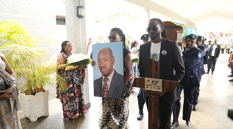 Family members hold a cross and portrait of the late MP Logan Ndahiro as the body arrives at Parliamentary Buildings in Kimihurura on November 3, 2019. / All photos: Emmanuel Kwizera