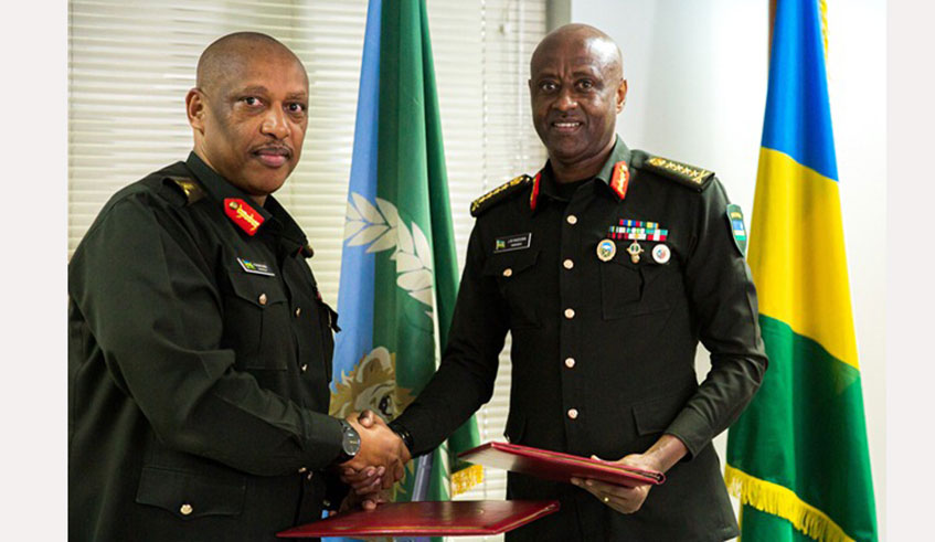 The new Chief of Defence Staff, General Jean-Bosco Kazura (right), and his predecessor whou2019s now the Minister for Internal Affairs, General Patrick Nyamvumba, exchange documents at a handover ceremony at the Ministry of Defence Headquarters in Kigali on November 5, 2019. Courtesy.
