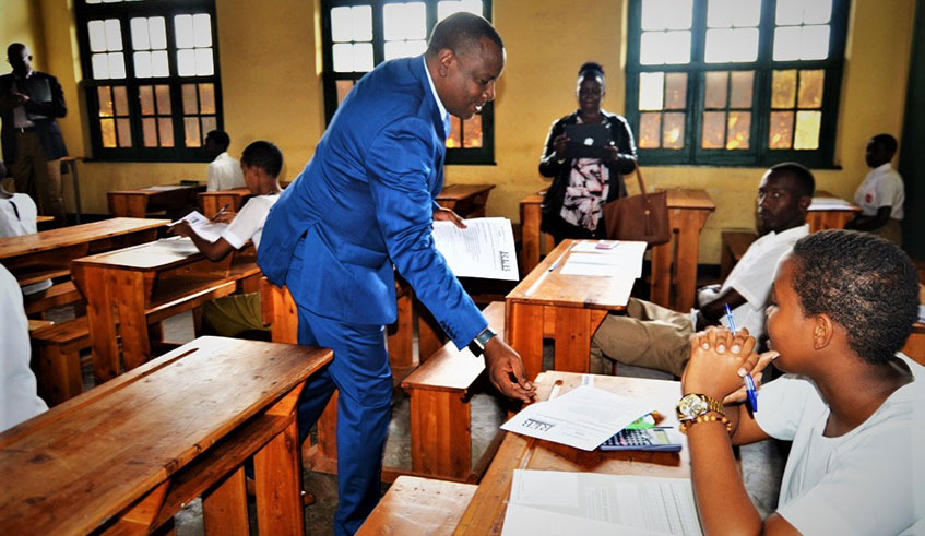 The State minister for Primary and Secondary Education, Isaac Munyakazi, distributes national examination papers to candidates at Group Scolaire de Butare on Tuesday. Some 171,123 students across the country are sitting the 2019 national examinations for Ordinary and Advanced levels of secondary schools. Photo: Moise B. Mugisha.