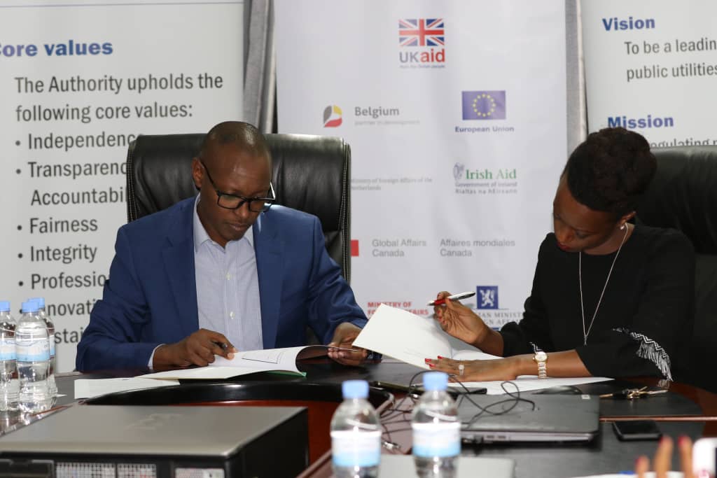 RURA's Director General Patrick Nyirishema (L) and TMEA's Rwanda's Country Director Patience Mutesi sign the deal at RURA Headquarters in Kigali.  