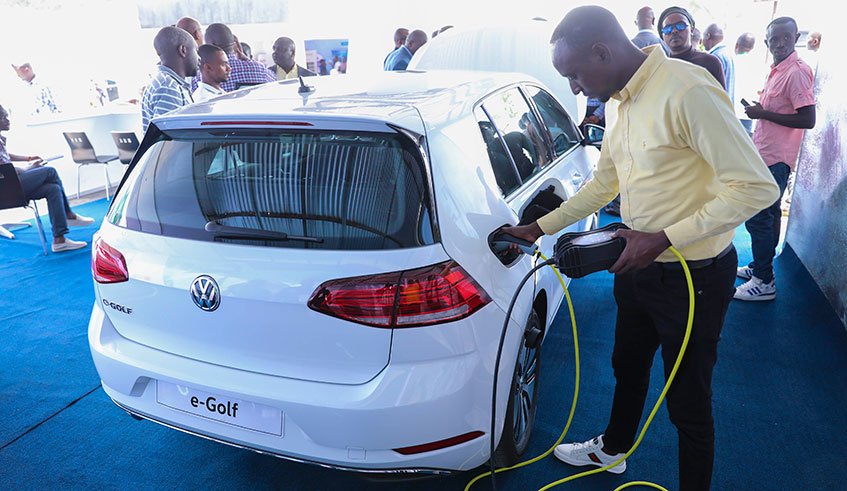 An employee of Volkswagen Mobility Solutions Rwanda demonstrates to Made in Rwanda expo goers how to charge the electric Golf that was introduced by the car maker on the Rwandan market. According to VW officials, there is currently one charging station located at the VW assembly plant in the Special Economic Zone in Masoro, Gasabo district. The expo was launched yesterday by trade and industry minister Soraya Hakuziyaremye. Emmanuel Kwizera. 