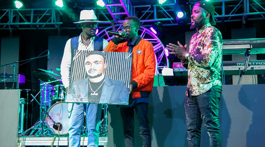 Uwikunda (C) surprised singer Social Mula by gifting him a portrait during his recent album launch. / Courtesy