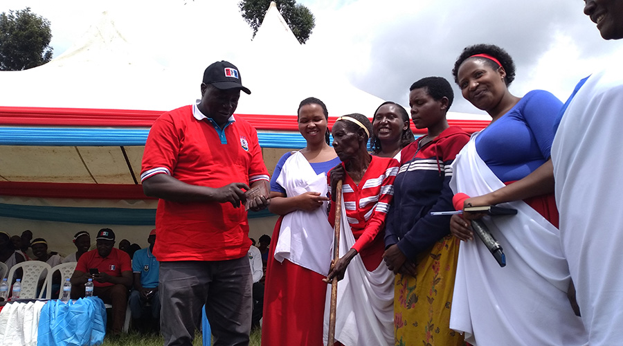 Governor Gatabazi counts Rwf100,000 that members of RPF-Inkotanyi womenu2019s league in Gicumbi District donated to Elvania Nyirabukeye for her to initiate a small business. / Photos by Ru00e9gis Umurengezi.