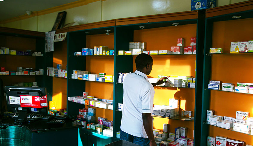 A  pharmacist goes through rows of drugs in a pharmacy in Kigali. Photo: Craish Bahizi.