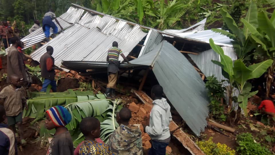 Residents try to regain iron sheets from a destroyed house in Muko Sector. Dozens of houses were destroyed through landslides in the district. Photo by Ru00e9gis Umurengezi