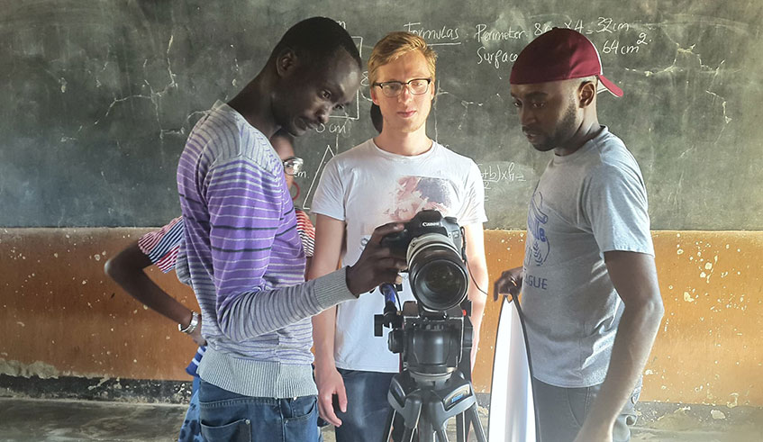 Arnold Mugisha (left) and his team go through a video at the set. /Courtesy photos.