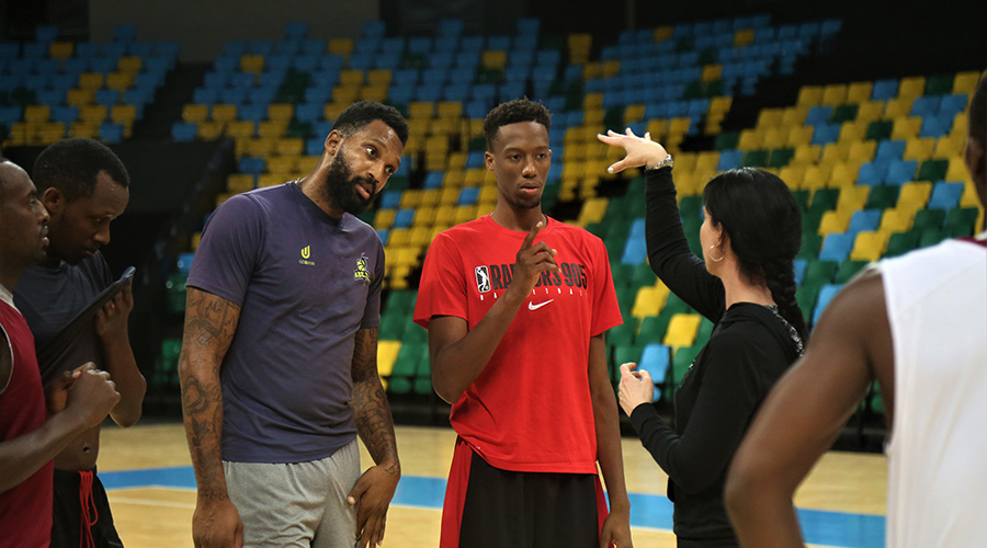 Patriotsu2019 new signings Jean-Victor Mukama (in red shirt) and Au2019Darius Lamar Pegue listen to assistant coach Liz Mills during training on Wednesday night at Kigali Arena. 