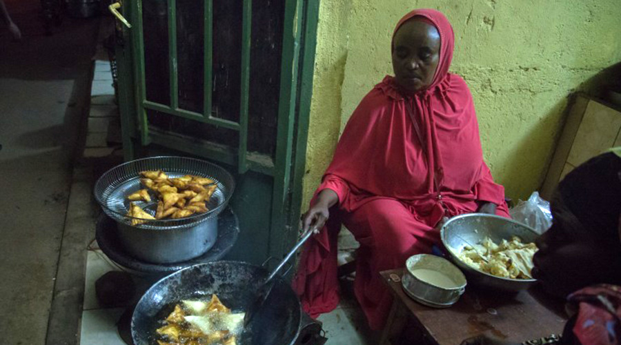 A woman makes ibiraha and samosas, some of the most popular street foods in Rwanda u2013 for her evening customers in Nyamirambo. 