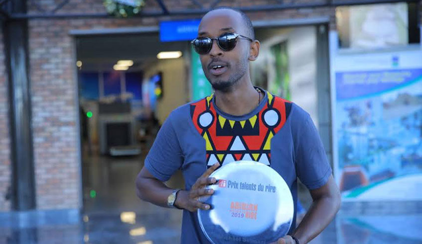 Sengazi shows off his award upon arrival at Kigali International Airport. Courtesy.
