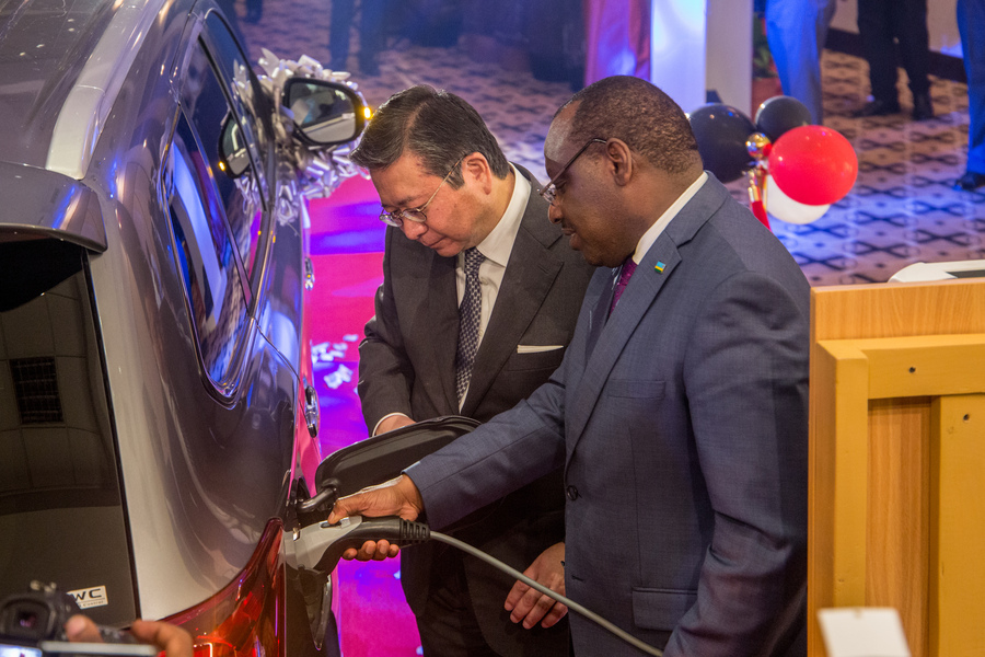 Ambassador Claver Gatete, Rwanda's Minister for Infrastructure and chief guest at the PHEV launch demonstrates how to charge the PHEV Oultlander using the ABB charger with the help of Mitsubishi Middle East and Africa President Mr. Takahashi Masahiko during the Friday 20 December unveiling of Africa's first plug-in hybrid vehicle. / Dan Nsengiyumva