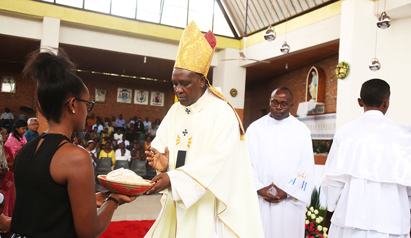 Archbishop of Kigali Archidiocese Antoine Kambanda blesses a lady who brings offerings during Mass at Saint Michel Cathedral on Christmas Day. Many preachers of different religious denominations focused their sermons on peace and love. Photo: 