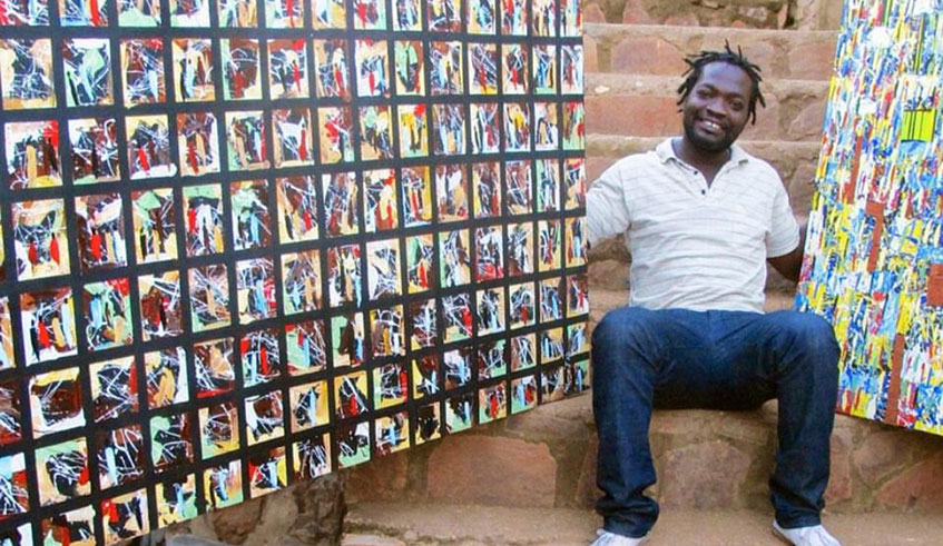 Jean Baptiste Mpungirehe shows off some of his paintings. 