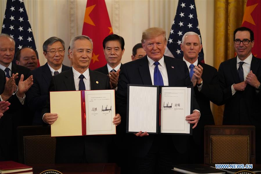 U.S. President Donald Trump and Chinese Vice Premier Liu He, who is also a member of the Political Bureau of the Communist Party of China Central Committee and chief of the Chinese side of the China-U.S. comprehensive economic dialogue, show the signed China-U.S. phase-one economic and trade agreement.