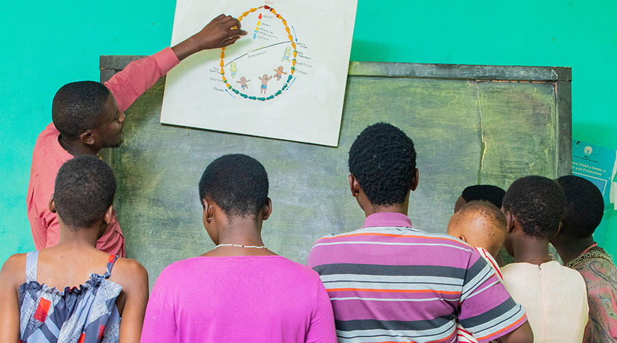 A group of teenage mothers are taken through the reproductive cycle by a health worker at Centre Marembo in Gasabo District. 