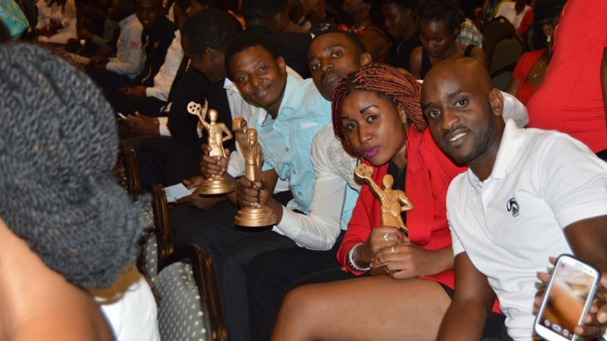 Winners of the previous Rwanda Movie Awards pose for a photo with their trophies. 