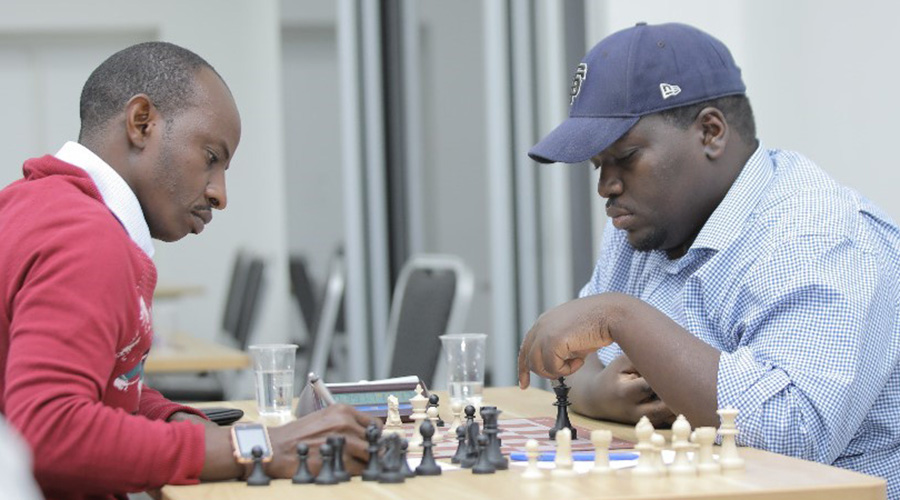 Ben Tom Zimurinda (L), seen here in a past match against national champion CM Godfrey Kabera, has picked up 2.5 points after four games in the first round qualifiers. 