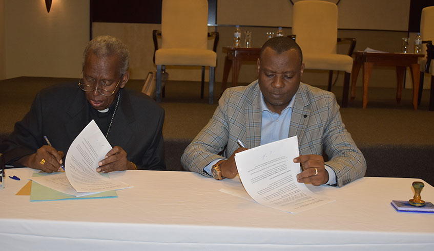 The Catholic Bishop of Kabgayi,Smaragde Mbonyintege, and the Minister of State in charge of Primary and Secondary Education, Isaac Munyakazi, during the signing of the agreement in Kigali on January 29. Craish Bahizi.