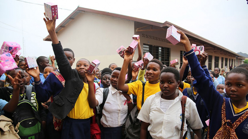 Girls from GS Kagugu raise aloft sanitary pads they received from #FreeThePeriod initiative last week. 