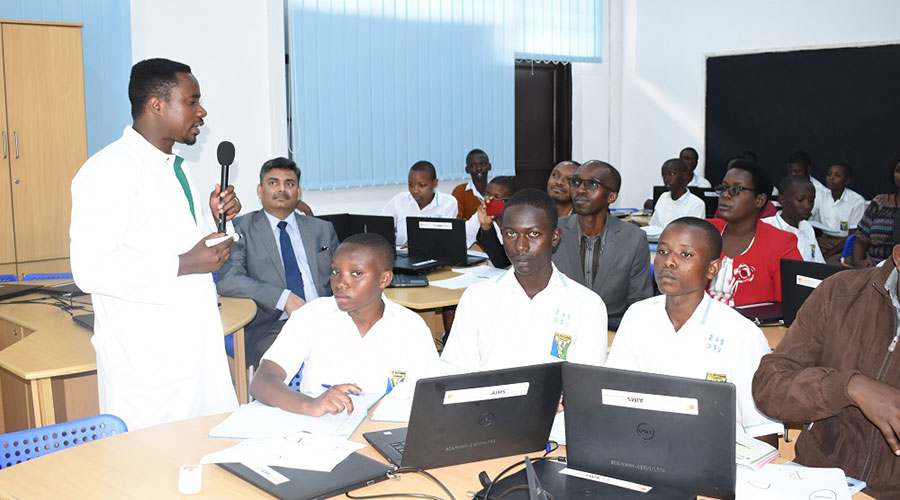 A teacher conducts a lesson in the smart classroom at Groupe Scolaire Rutobwe in Kamonyi District yesterday as officials look on. 