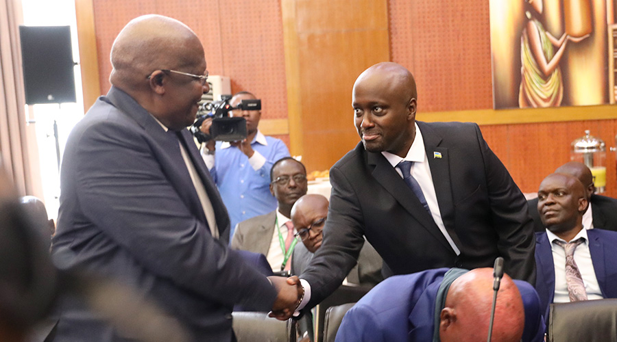 Amb. Olivier Nduhungirehe, Rwanda's Minister of State in charge of the East African Community shakes hands with Ugandan Foreign Minister Sam Kuteesa during the first meeting of the Ad Hoc Commission on the implementation of the Luanda MoU between Rwanda and Uganda in Kigali, in September 16, 2019. 