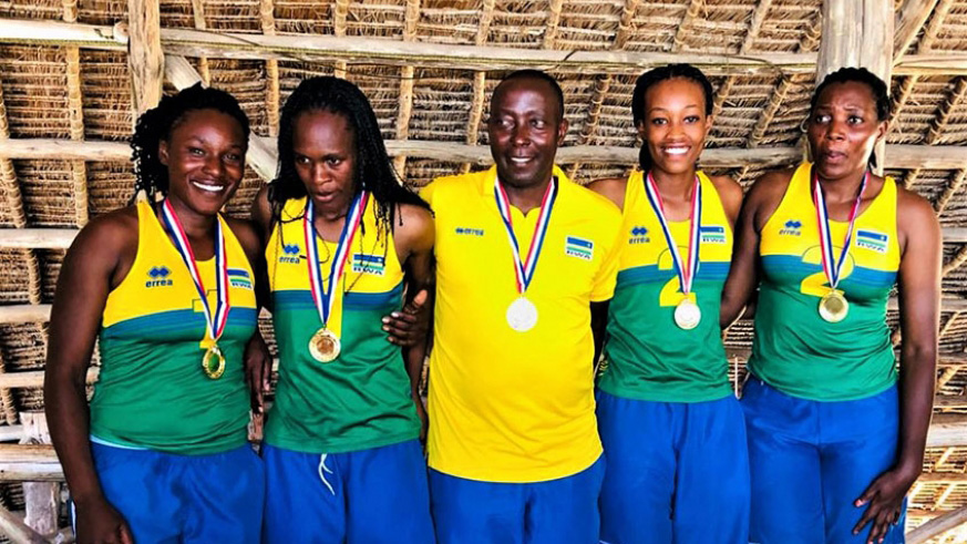 Head coach Christophe Mudahinyuka (C) and the two Rwandan teams pose for a group photo with medals after finishing top of sub-zone 5 qualifiers in Tanzania last month. 