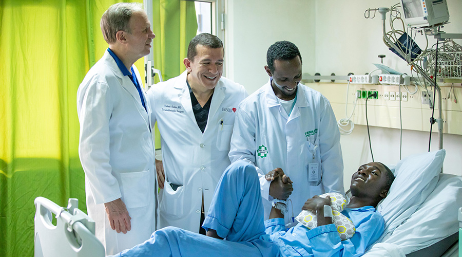 (Right-left) Dr Maurice Musoni, Rwandau2019s first cardiothoracic surgeon; Lead surgeon Dr Robert Oakes and Team Heart founder Dr Chip Bolman talk to Emmanuel Niyobuhungiro after he had undergone heart surgery at King Faisal Hospital, Kigali on February 13. Rwandan medics are set to independently start carrying out open-heart surgeries this year, a milestone for the countryu2019s health sector. 