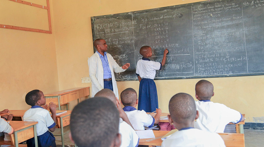 A teacher helps a pupil during a mathematics lesson. 