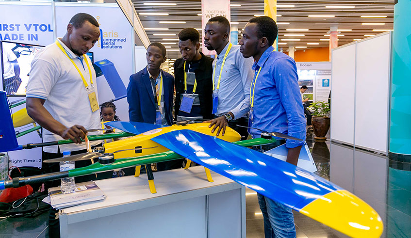 Participants at the African Drone Forum in Kigali examine one of the drones on display. Leapr Labs, a local drones company, signed deals with three drone companies and a Dutch University. / Emmanuel Kwizera.