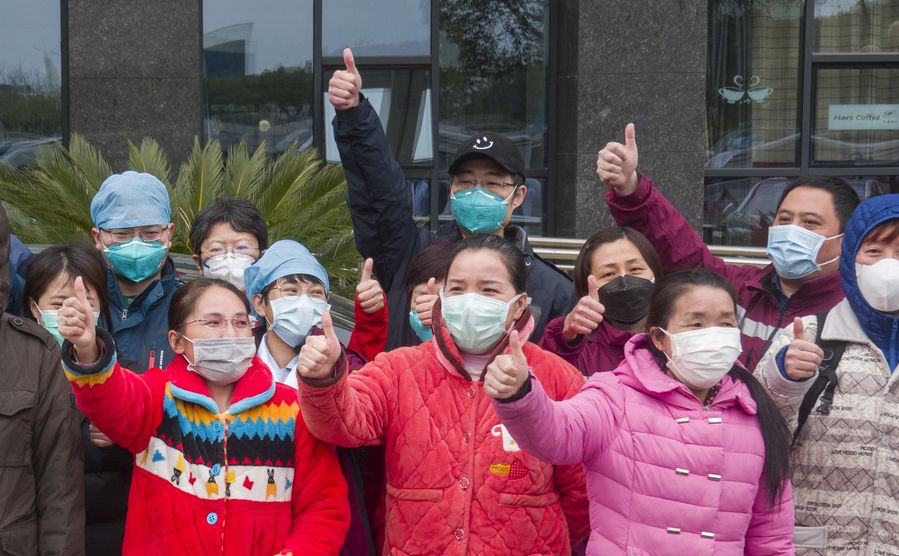 The recovered patients with severe novel coronavirus pneumonia (NCP) pose for photos with medical staff at the west campus of Wuhan Union Hospital in Wuhan, central China's Hubei Province, Feb. 19, 2020. 
