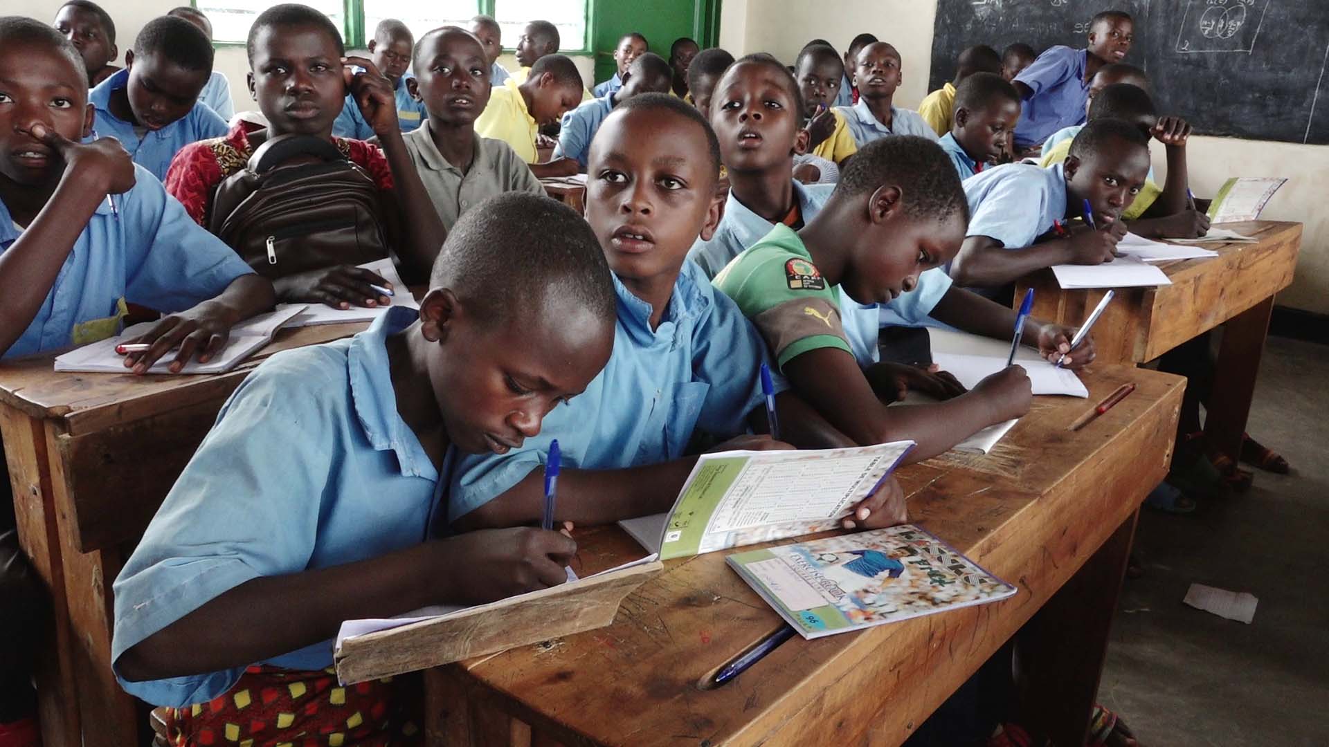 Students of Groupe Scolaire Paysannat L write in their notebooks during a lesson. The Rwanda Education Board says the school is the most overcrowded in Rwanda with almost 24,000 thousand students. / All photos by Glory Iribagiza