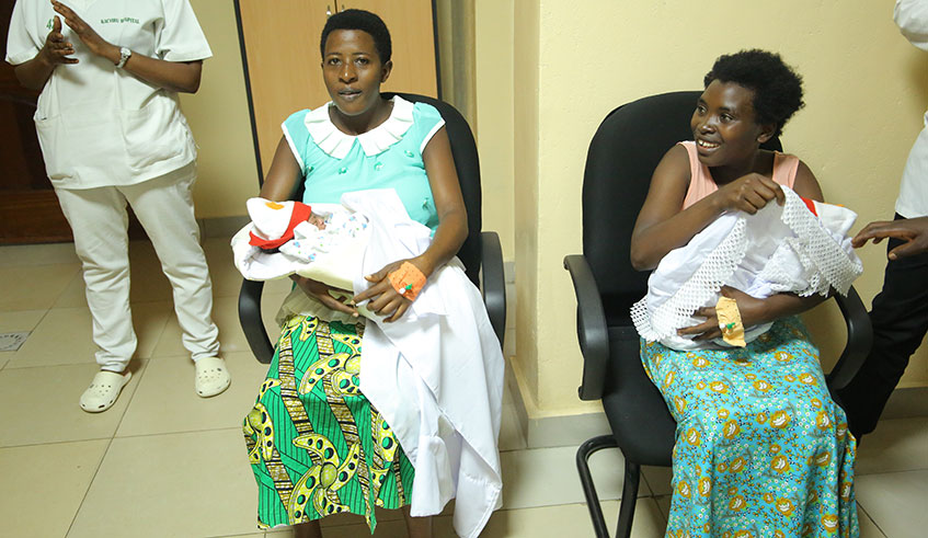 Two women carry their babies who were born on Christmas at Kacyiru Hospital. Parents are upbeat about the new system, which allows them to register their children from health centres at birth. / Craish Bahizi.