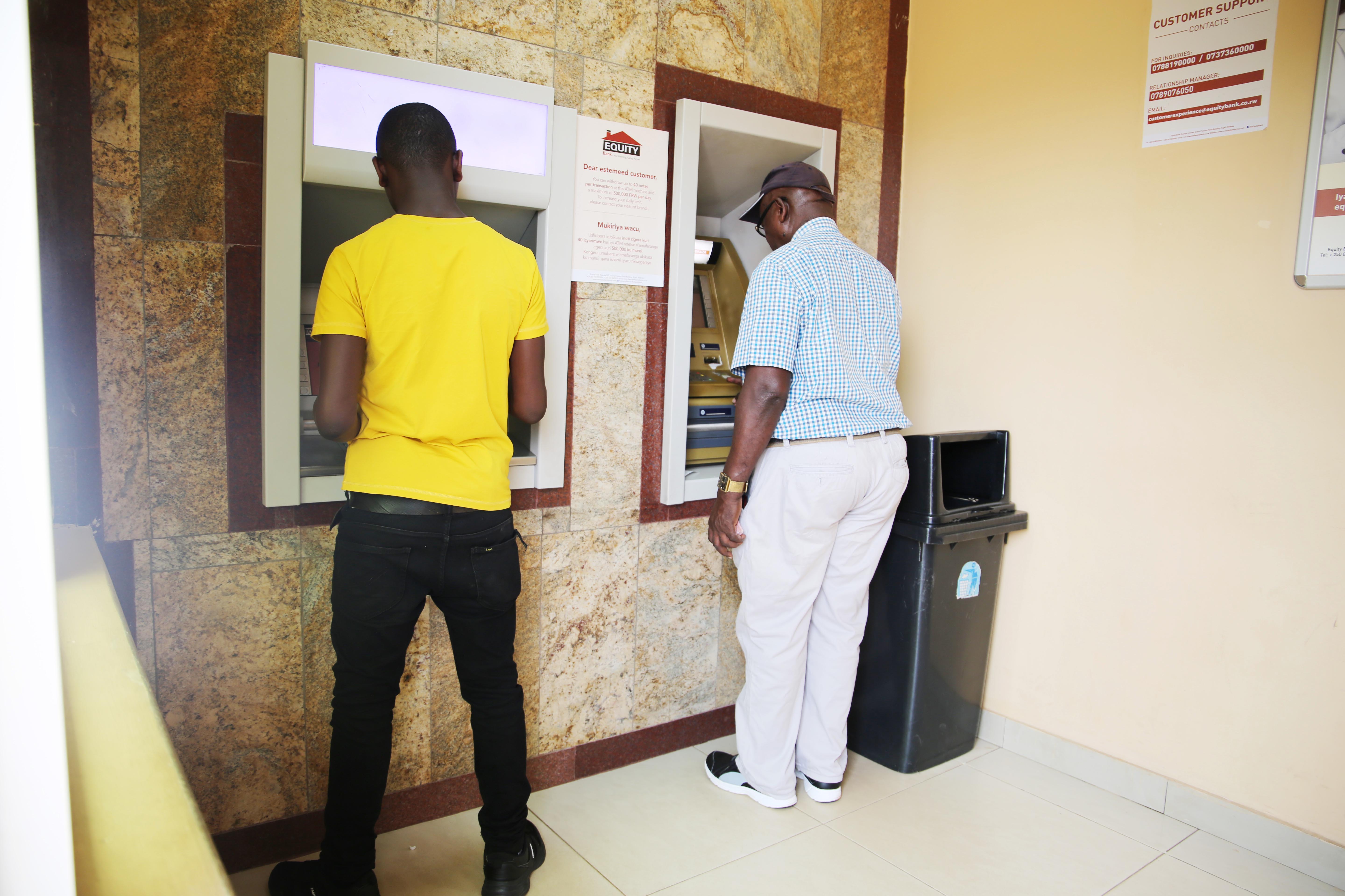 A mobile money agent and his clients wear facemasks in Kigali yesterday (Craish Bahizi)