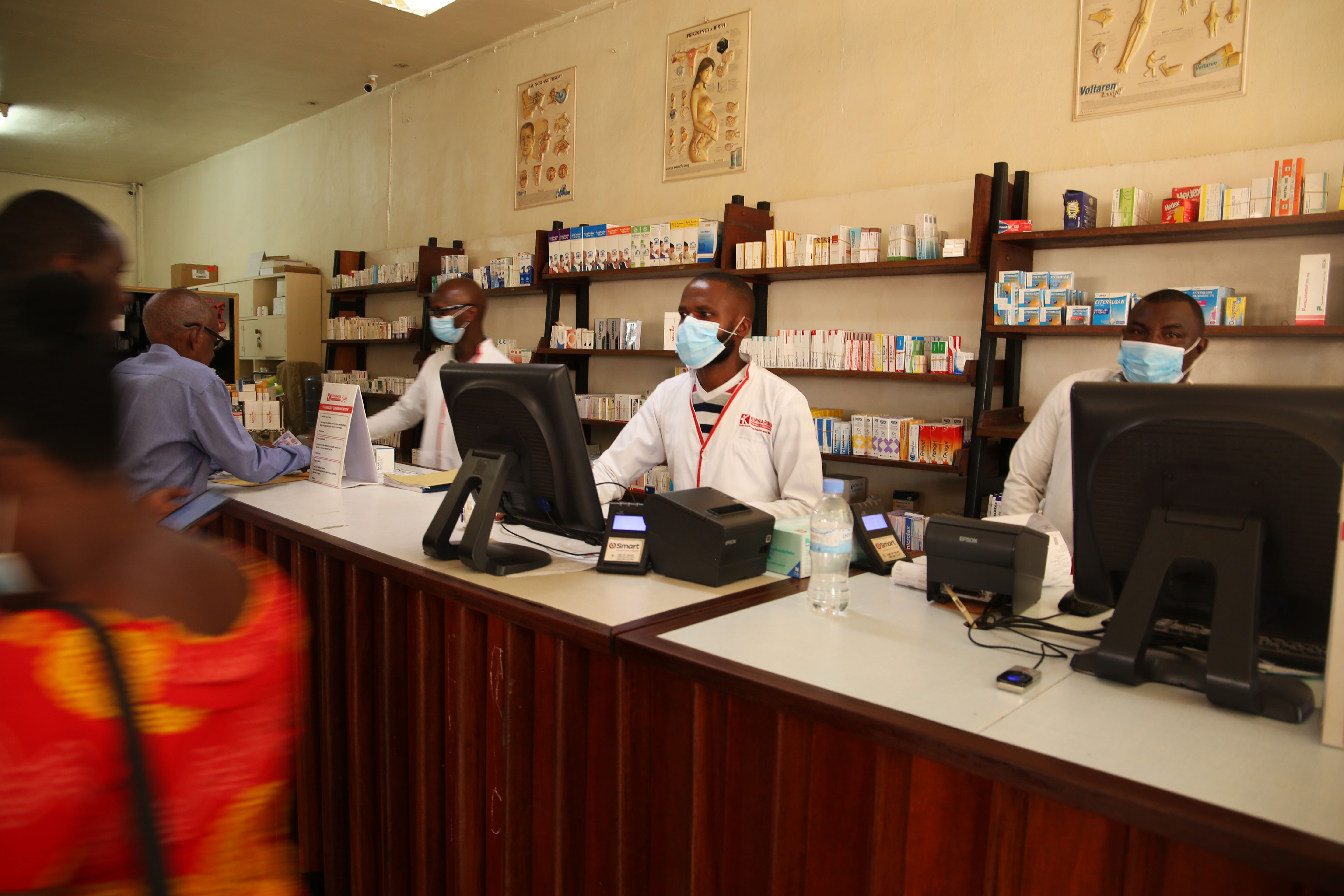 A mobile money agent and his clients wear facemasks in Kigali yesterday (Craish Bahizi)