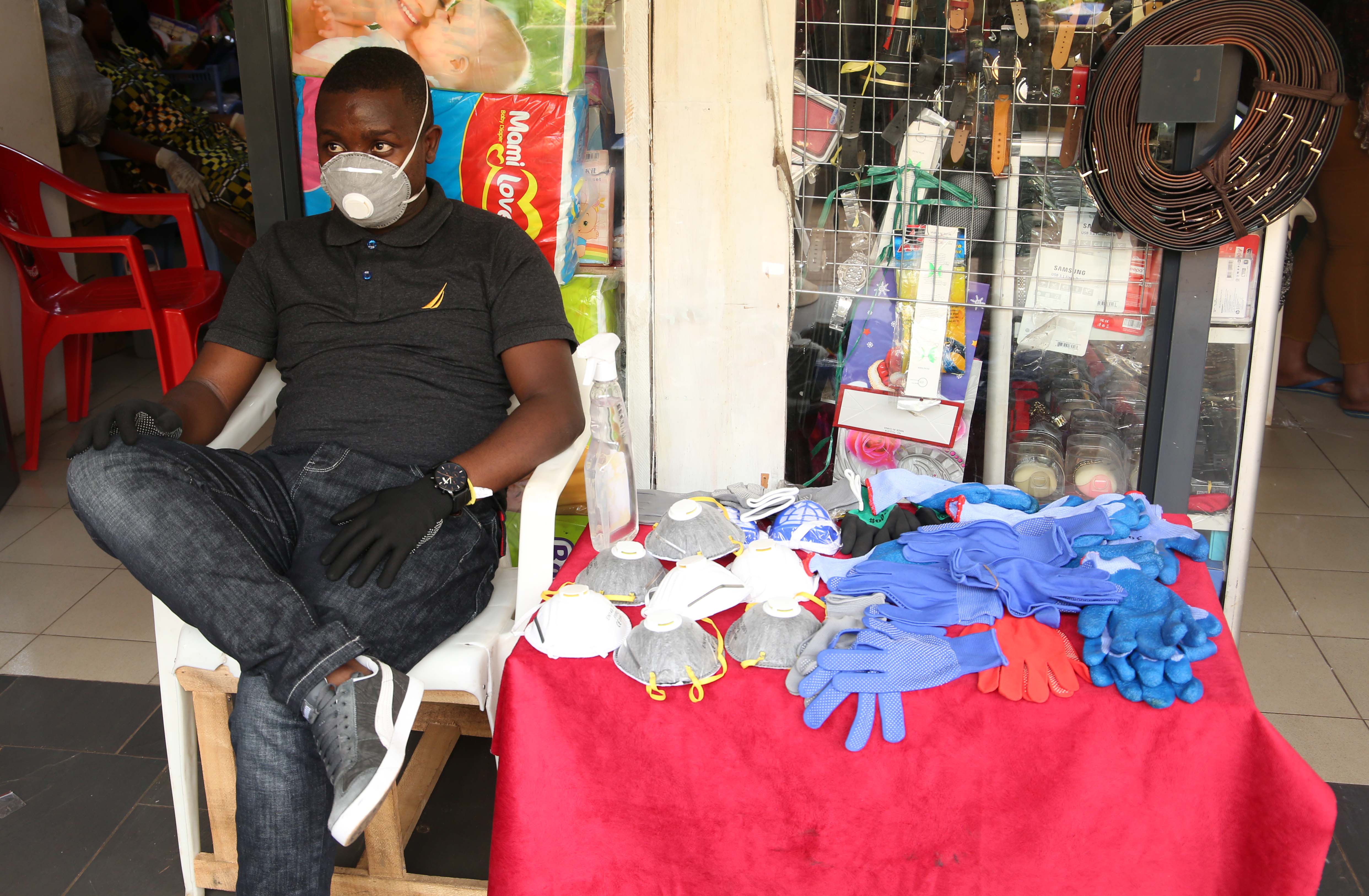 A mobile money agent and his clients wear facemasks in Kigali yesterday (Craish Bahizi)